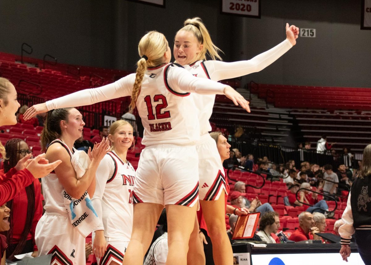 Sophomore guard Shannon Blacher (12) and junior forward Reagan Barkema (23) chest bump in celebration after Barkema's three-pointer tied the game at 55-55 against the University of Louisiana at Lafayette Ragin' Cajuns on Monday. The Huskies overcame the Ragin' Cajuns 57-55 in their home and season opener. (Katie Follmer | Northern Star)