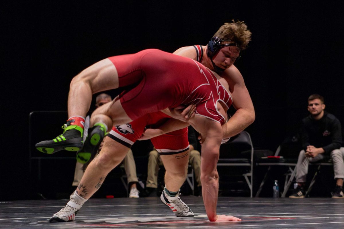 Redshirt junior Jacob Christensen lifts Rider University freshman Collin French off the mat to slam him back down on Friday at the Convocation Center. Christensen won the final match to seal a 20-19 victory for NIU wrestling over the Broncs. (Totus Tuus Keely | Northern Star)