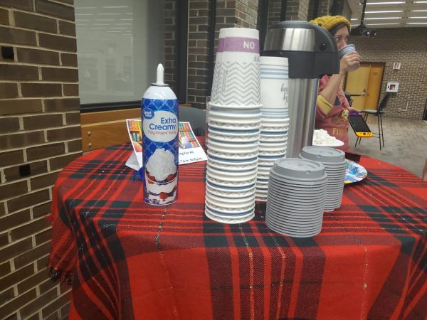 Hot chocolate, marshmallows and whipped cream sit on a table in the library. The members of Gaming For All invited students to enjoy some hot cocoa and games Wednesday evening. (Jonathan Shelby | Northern Star)