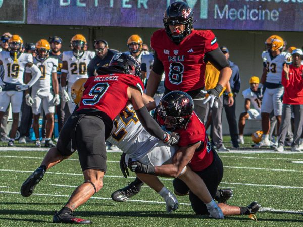 NIU senior safety Nate Valcarcel (9) assists senior linebacker Jaden Dolphin (26) in a tackle during the 117th Homecoming game against University of Toledo on Oct. 19 at Huskie Stadium in DeKalb. Valcarcel and seven other Huskies received all-conference honors from the Mid-American Conference on Thursday. (Totus Tuus Keely | Northern Star)