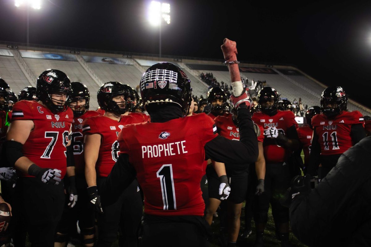 Senior defensive back Jashon Prophete (1) holds a bone in the air in front of his teammates after NIU football's 24-16 win against the Central Michigan University Chippewas on Saturday. The Huskies celebrated senior night during their final game of the regular season on Saturday and celebrated 30 seniors, 20 of which have spent their whole college career at NIU. (Totus Tuus Keely | Northern Star)