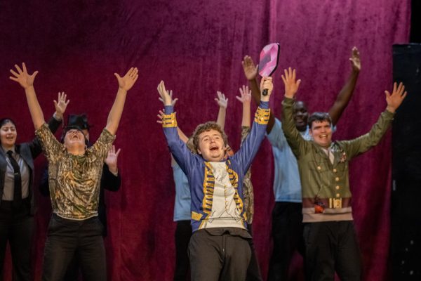 NIU Penguin Players raise their arms and sing the pickleball song during their performance on Sunday inside the Cavan Auditorium at Gabel Hall. NIU’s Penguin Players is a group that provides adults with disabilities the chance to perform a musical. (Tim Dodge | Northern Star) 