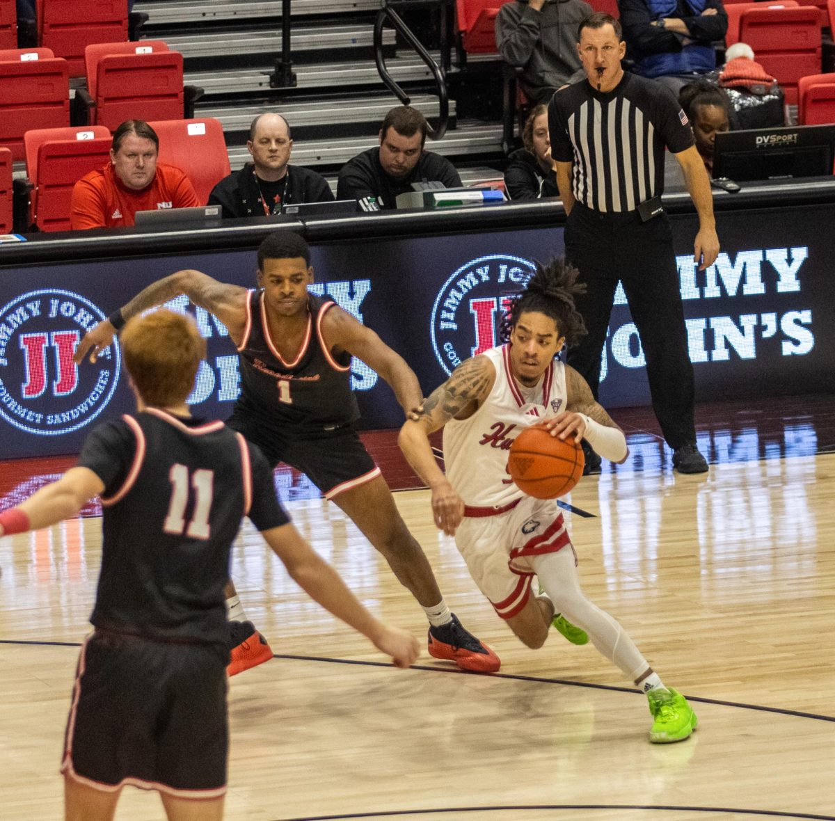 Sophomore guard Kailon Nicholls (5) cuts around Benedictine University junior guard Brandon McCoy (1) and charges towards the basket on Tuesday at the Convocation Center. Nicholls finished with a career-high 14 points as NIU men's basketball defeated Benedictine 89-70 on Tuesday. (Tim Dodge | Northern Star)