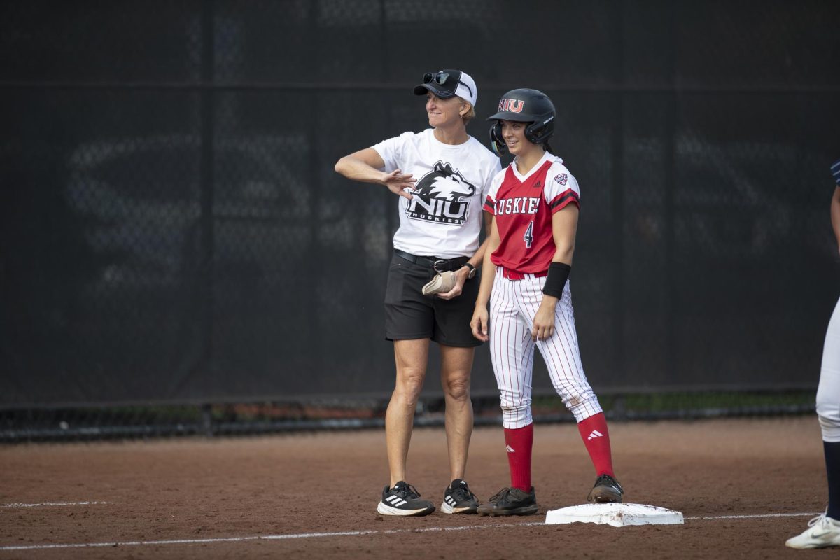 NIU head softball coach Kathryn Gleason guides NIU senior outfielder Jenna Turner while at third base during an exhibition game in the fall. The Huskies kick off their season at 4:30 p.m. Thursday for the Grand Canyon Tournament in Phoenix, Arizona. (photo courteNIU Athletics)