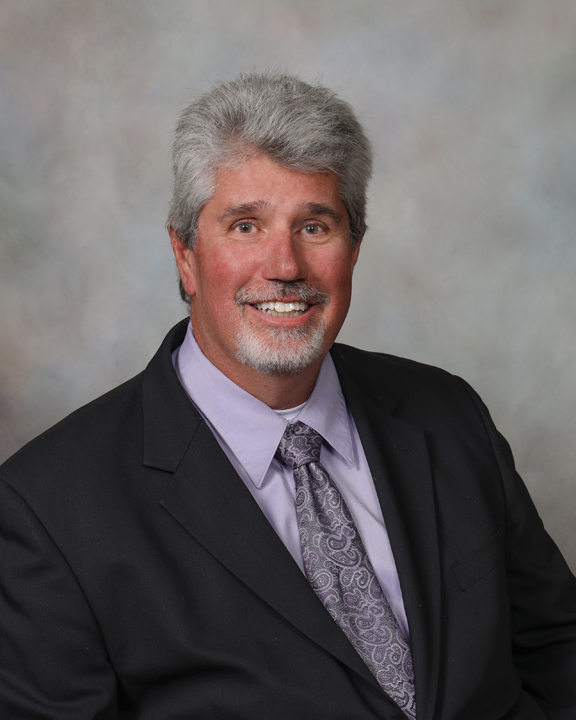 Charles (Chuck) Rose, a Sycamore attorney, sits in front of a gray background. Rose was hired to be the new interim director of Student’s Legal Assistance and will begin work on Feb. 1. (Courtesy of Charles Rose)