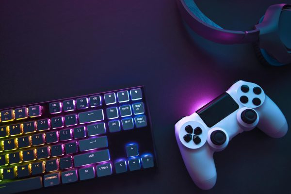 A white PlayStation controller rests next to a neon keyboard. Several sequels to popular games such as "Elden Ring" and "Grand Theft Auto V" are scheduled to be released later this year. (GettyImages) 