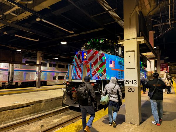 Passengers board the festive themed Metra Train Number 500. Metra Number 500 is an EMD SD70MAC that was purchased in 2019 and debuted in 2022. (Ryan Day | Northern Star)