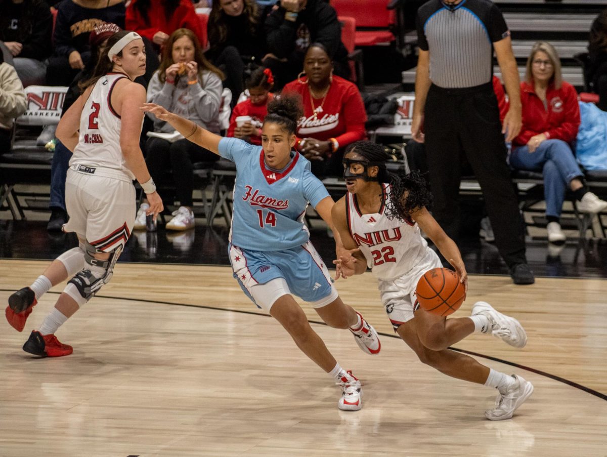 NIU women's basketball junior guard Alecia Doyle (22), battles with University of Illinois Chicago senior guard Krystyna Ellew (14) in the Huskies' 69-66 loss against UIC on Nov. 27. The Huskies snapped a five-game losing streak Wednesday, overcoming Eastern Michigan University by a score of 78-70. (Tim Dodge | Northern Star)