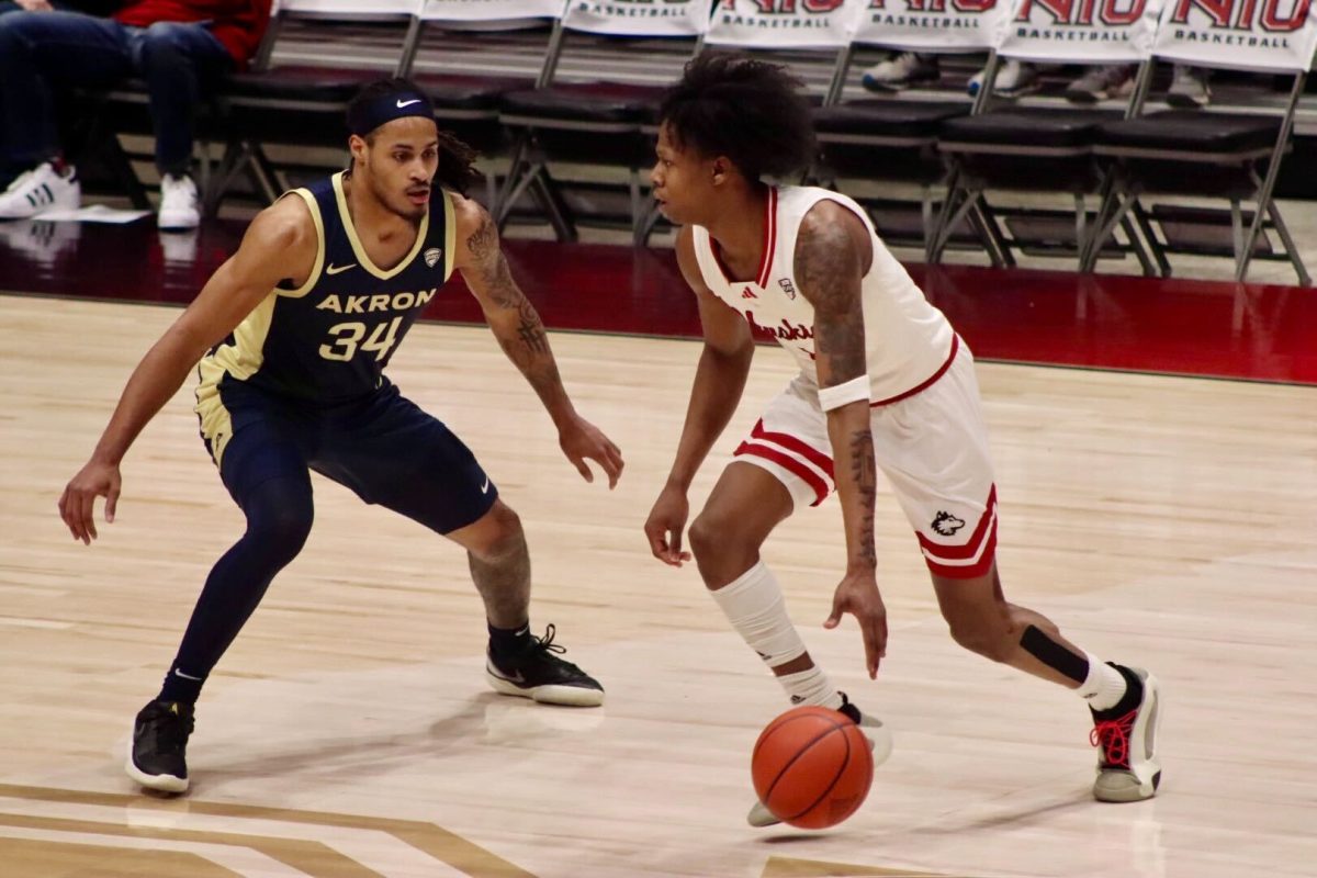 NIU men's basketball sophomore guard Quentin Jones dribbles the ball past University of Akron redshirt junior guard Nate Johnson Tuesday at the Convocation Center in DeKalb. Jones had 25 points in NIU's 80-70 loss against Akron. (Marco Alvarez | Northern Star)