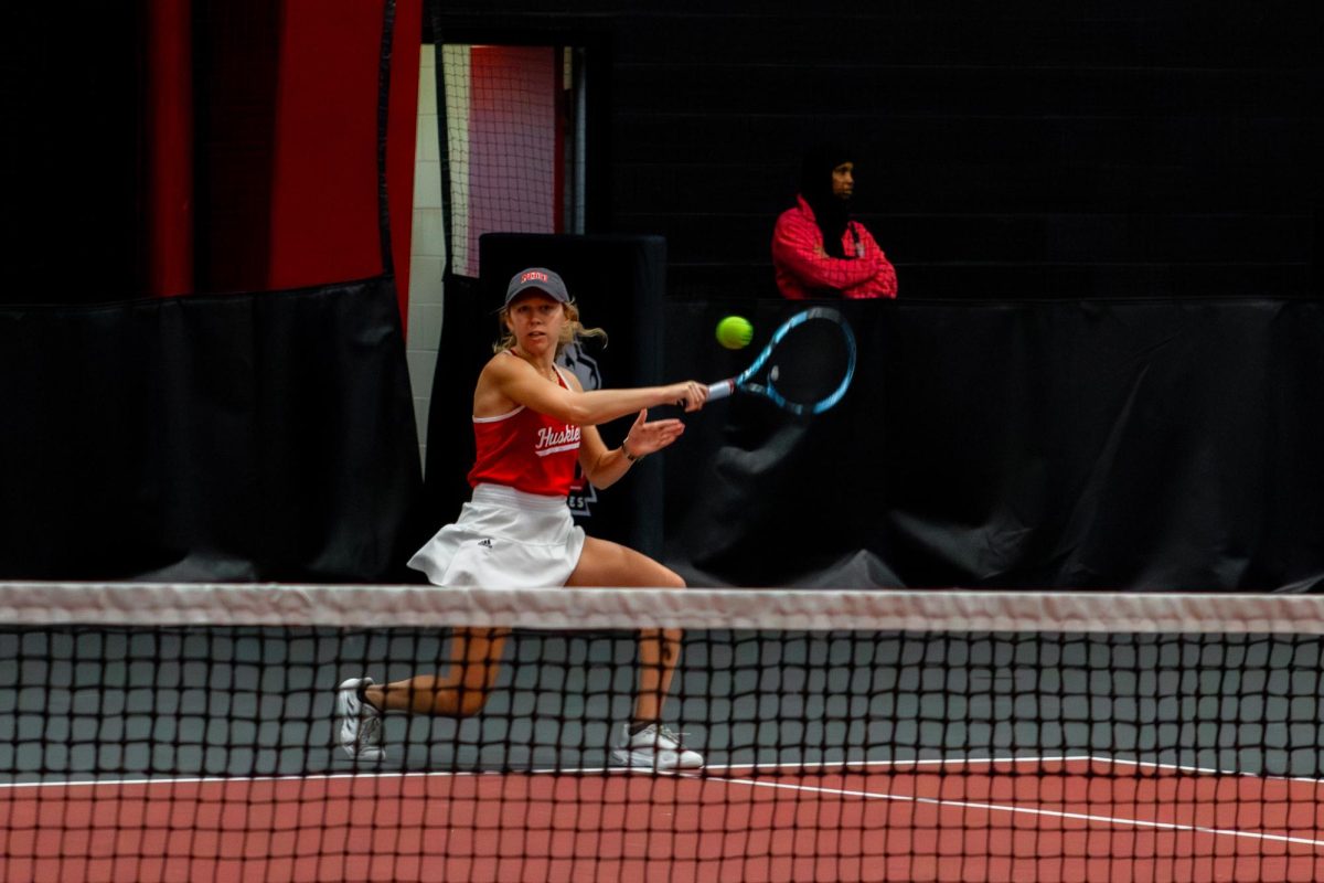 Junior Jenna Horne lunges and returns the ball during her doubles match against Lewis University. Horne snatched a singles victory over University of Notre Dame freshman Bianca Molnar in three sets Saturday at the Northwestern Invitational. (Totus Tuus Keely | Northern Star)