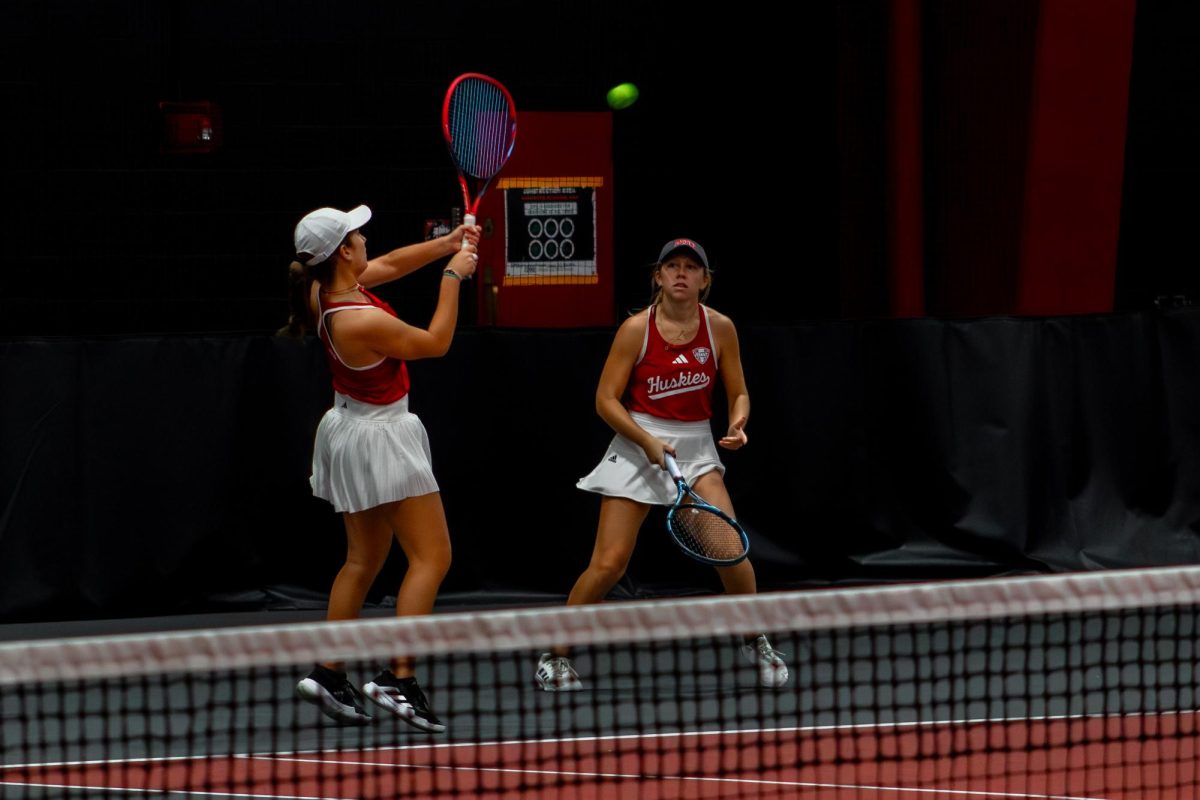 NIU women's tennis freshman Lucia Yecora returns the ball with a two-handed swing during her doubles match with junior Jenna Horne against Lewis University on Nov. 13 at the Huskie Invitational. NIU picked up two 7-0 victories Saturday over the University of Northern Iowa and Eastern Illinois University. (Totus Tuus Keely | Northern Star)