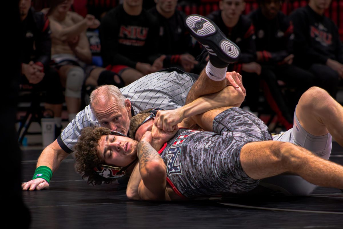  Redshirt sophomore Tommy Curran attempts to break loose from Purdue redshirt sophomore Isaac Ruble on the mat. Curran scored only three points in the 149-pound match, losing by major decision, 14-3. (Totus Tuus Keely | Northern Star)