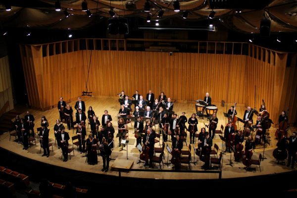 Director Linc Smelser bows at the end of the Arthur D. Montzka Memorial Concert as the audience roars with applause. The Arthur D. Montzka Memorial Concert was named after Arthur Dale Montzka, the first director of the Kishwaukee Symphony Orchestra after his passing in 2002. (Ethan Rodriguez | Northern Star)