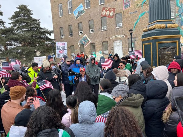 DeKalb resident Norma Gregorio-Perez speaks to a group of protestors gathered at the corner of Lincoln Hwy and 1st Street. Gregorio-Perez said since January immigrants have been living in fear of their safety. (Devin Oommen | Northern Star)