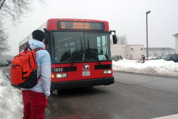 Sophomore kinesiology major Mitchell Rodriguez waits for the No. 11 weekend break circle route bus on Blackhawk Road in 2015. Huskie Buses will now have DeKalb police officers patrolling them as part of a new safety initiative. (Northern Star File Photo)