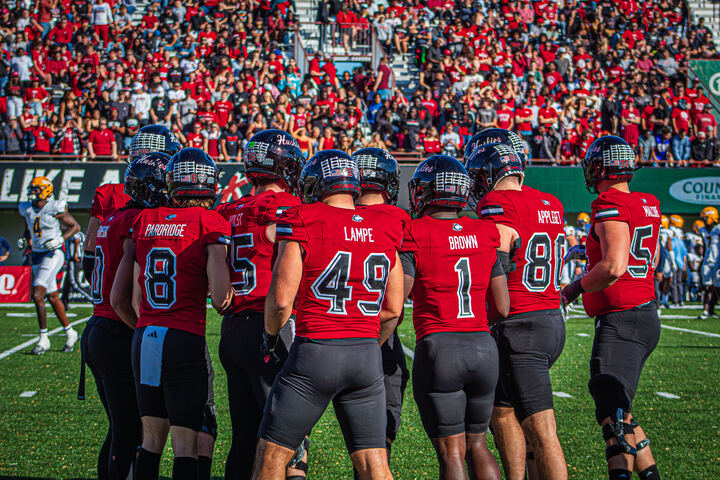 Members of the NIU football team gather in the huddle during the 117th Homecoming game against the University of Toledo on Oct. 19 at Huskie Stadium in DeKalb. NIU signed four football players on National Signing Day on Wednesday, putting the Huskies’ 2025 recruiting class at 24 signees. (Totus Tuus Keely | Northern Star)