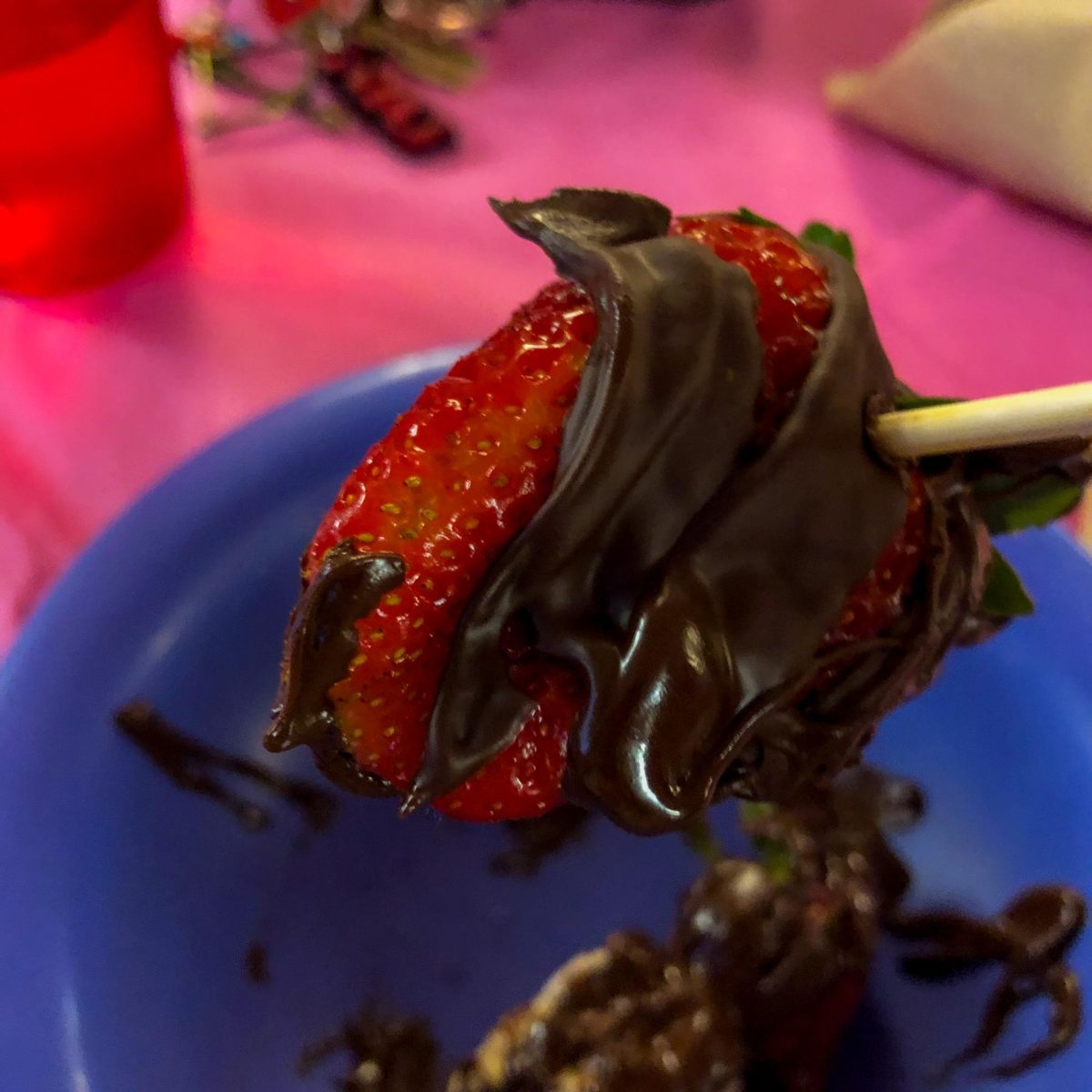 A chocolate covered strawberry sits on a stick. Neptune Dining’s 70s Dinner is an homage to the groovy decade. (Jenny Javkhlantugs | Northern Star)