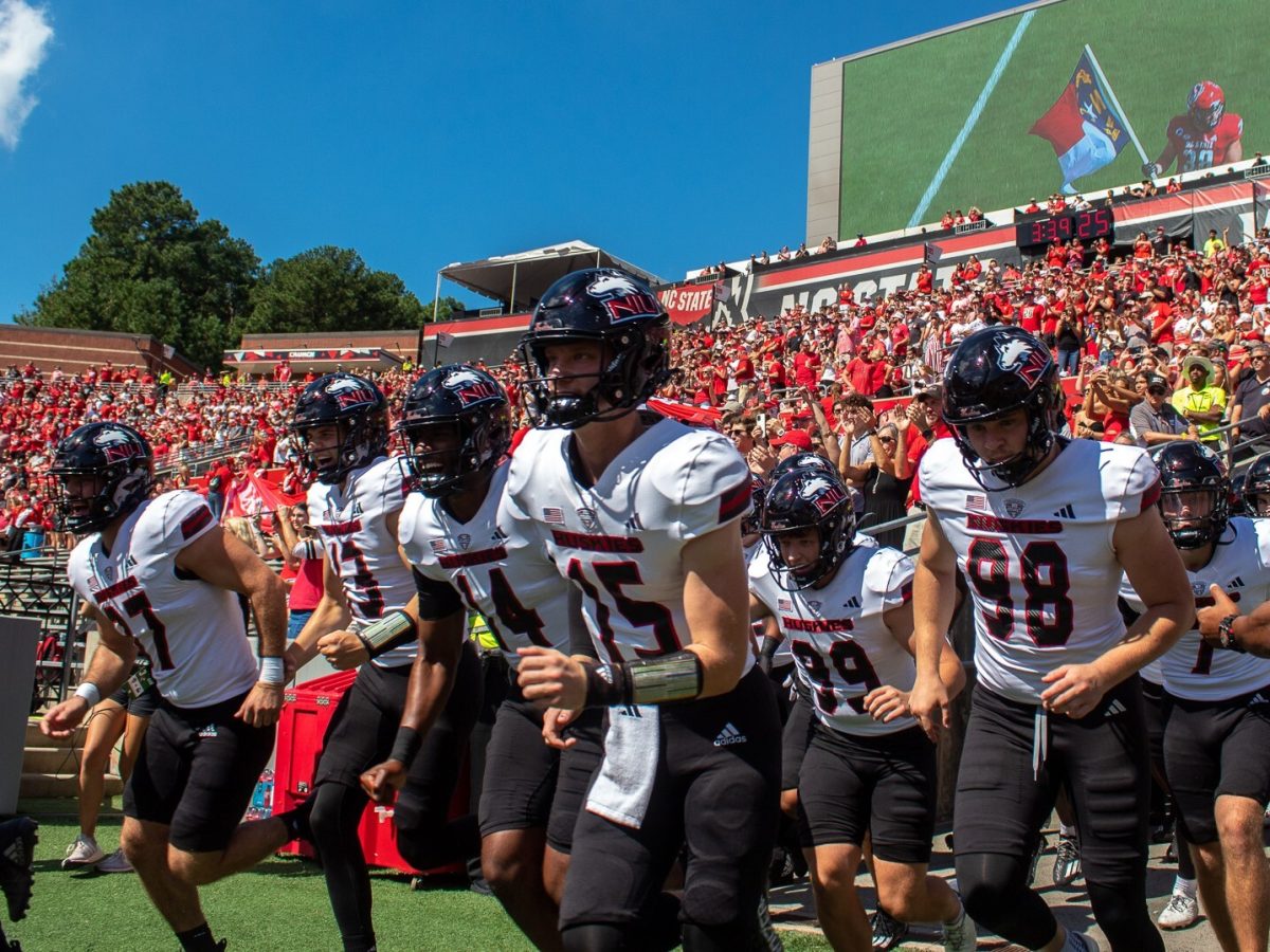 NIU football players run onto the field ahead of their non-conference game against North Carolina State University on Sept. 28 at Carter-Finley Stadium in Raleigh, North Carolina. On Wednesday, NIU released its football schedule for the 2025 season, which will be its last in the Mid-American Conference. (Totus Tuus Keely | Northern Star)