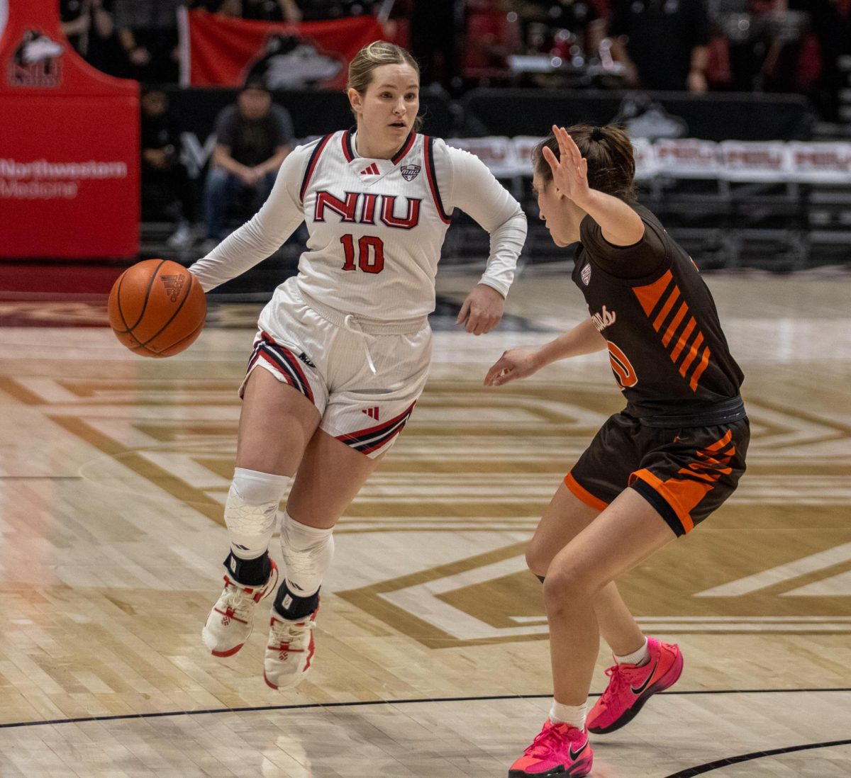 NIU women's basketball graduate student guard Chelby Koker drives with the basketball against a Bowling Green defender. After posting back-to-back double-digit performances, Koker was awarded Mid-American Conference Player of the Week. (Tim Dodge | Northern Star)