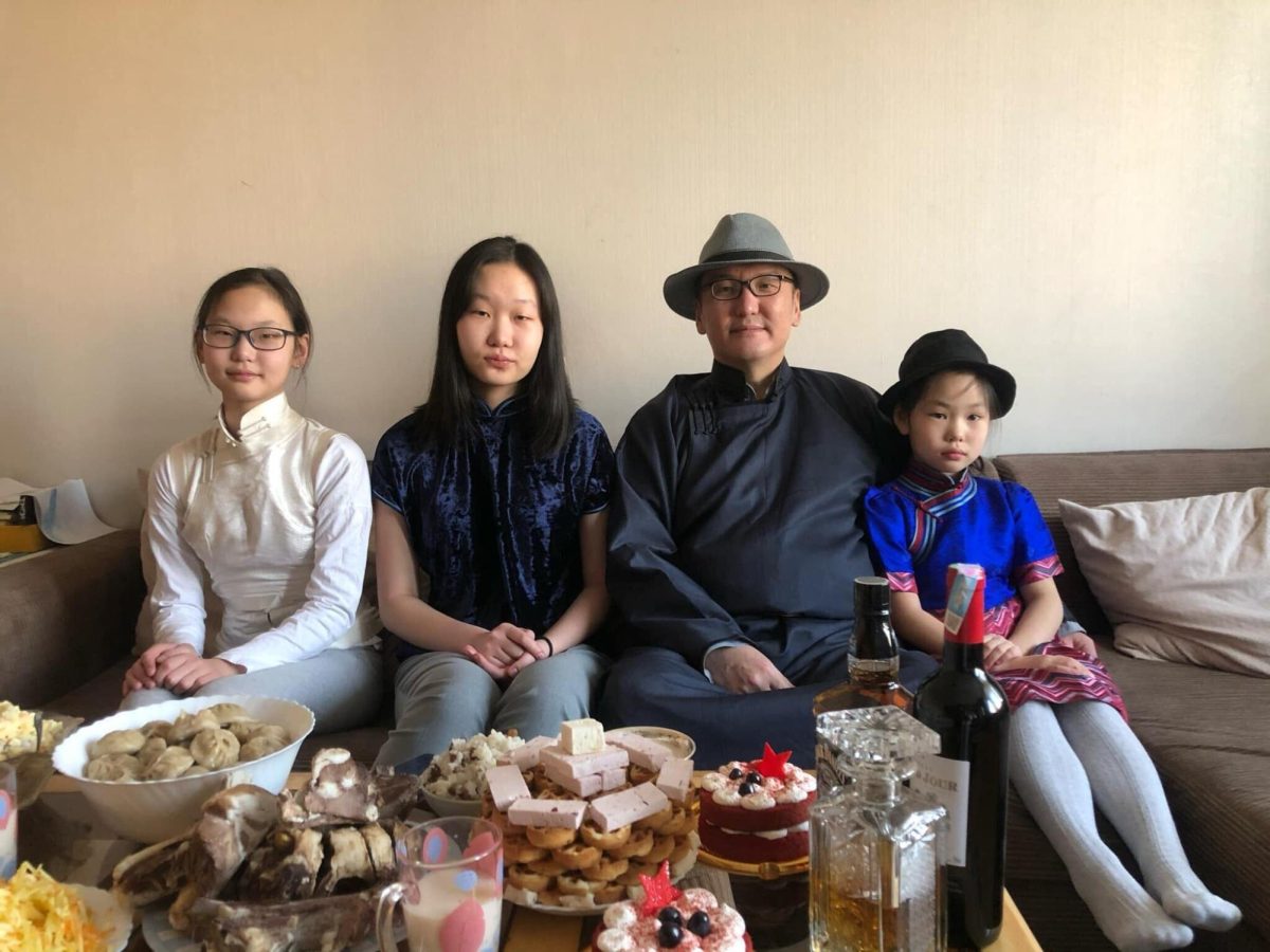 A photo shows Video Editor Jenny Javkhlantugs sitting on a couch with her family with a table full of food in front of them. The Mongolian Lunar New Year ran from Saturday through Monday and represents the beginning of a new year based on the Mongolian lunar calendar. (Jenny Javkhlantugs | Northern Star)