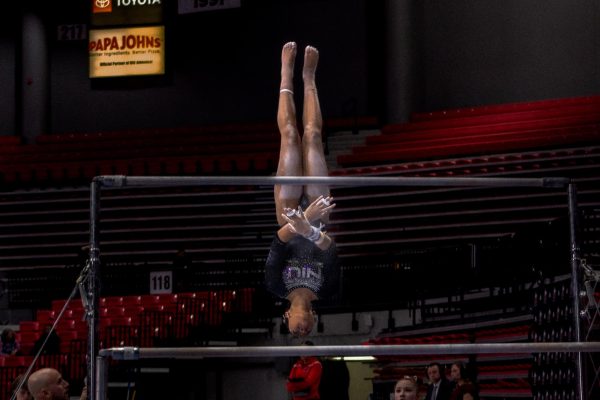 NIU gymnastics freshman Drake White flips into her dismount off the uneven bars during the Huskies’ meet against Illinois State University on Jan. 25. The Huskies defeated Bowling Green State University in their last home meet of the season on Sunday. (Totus Tuus Keely | Northern Star)