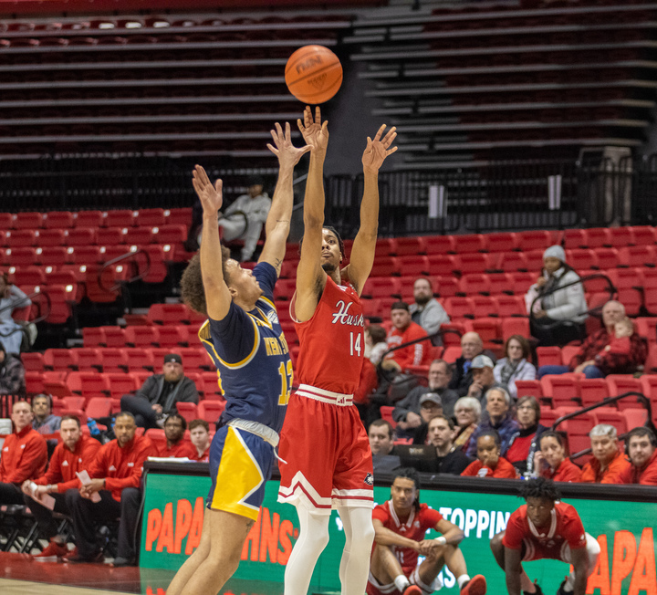 NIU men's basketball senior guard James Dent Jr. (14) attempts a contested field goal against Kent State University senior guard Jalen Sullinger (13) amid the Huskies' 68-50 loss against Kent State on Jan. 7. NIU snapped an 11-game losing skid Friday, overcoming Central Michigan University by a score of 83-81 in double overtime.(Tim Dodge | Northern Star)