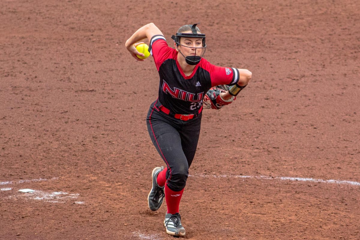 Freshman pitcher Taylor Mackin (23) pitches to University of Akron junior left fielder Meagan Lee (77) in the seventh inning on Friday. The Huskies closed out a three-game series against the Zips on Saturday, splitting wins in a doubleheader. (Totus Tuus Keely | Northern Star)