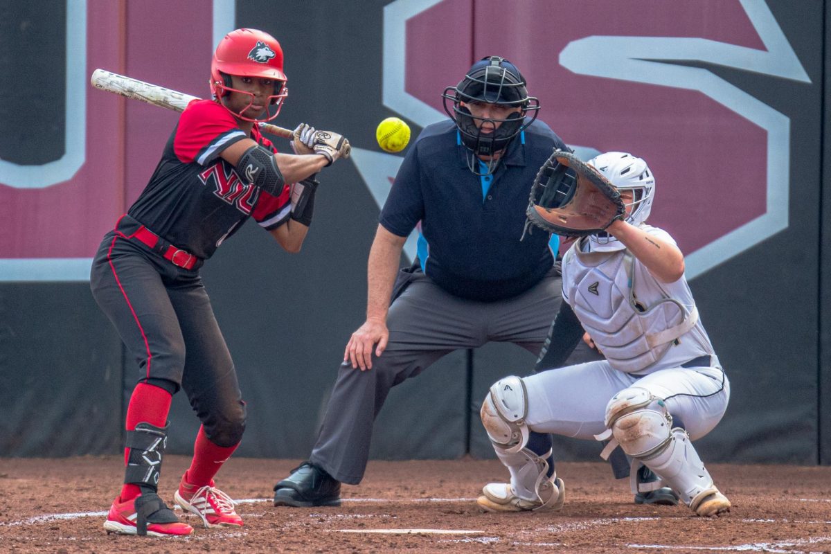 Sophomore shortstop Alana Powell (8) watches a ball pass home plate during the third inning. Powell hit a homerun past right field during the fifth inning, earning NIU their second and last run of the game. (Totus Tuus Keely | Northern Star)