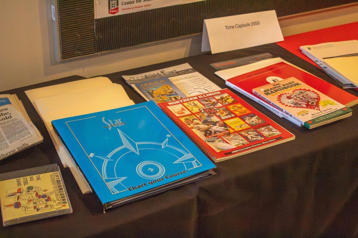 Various papers and folders rest on a table. The Northern Star opened its 25-year-old time capsule Wednesday in front of students, DeKalb residents and NIU alumni. (Totus Tuus Keely | Northern Star)