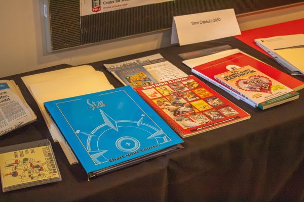 Various papers and folders rest on a table. The Northern Star opened its 25-year-old time capsule Wednesday in front of students, DeKalb residents and NIU alumni. (Totus Tuus Keely | Northern Star)
