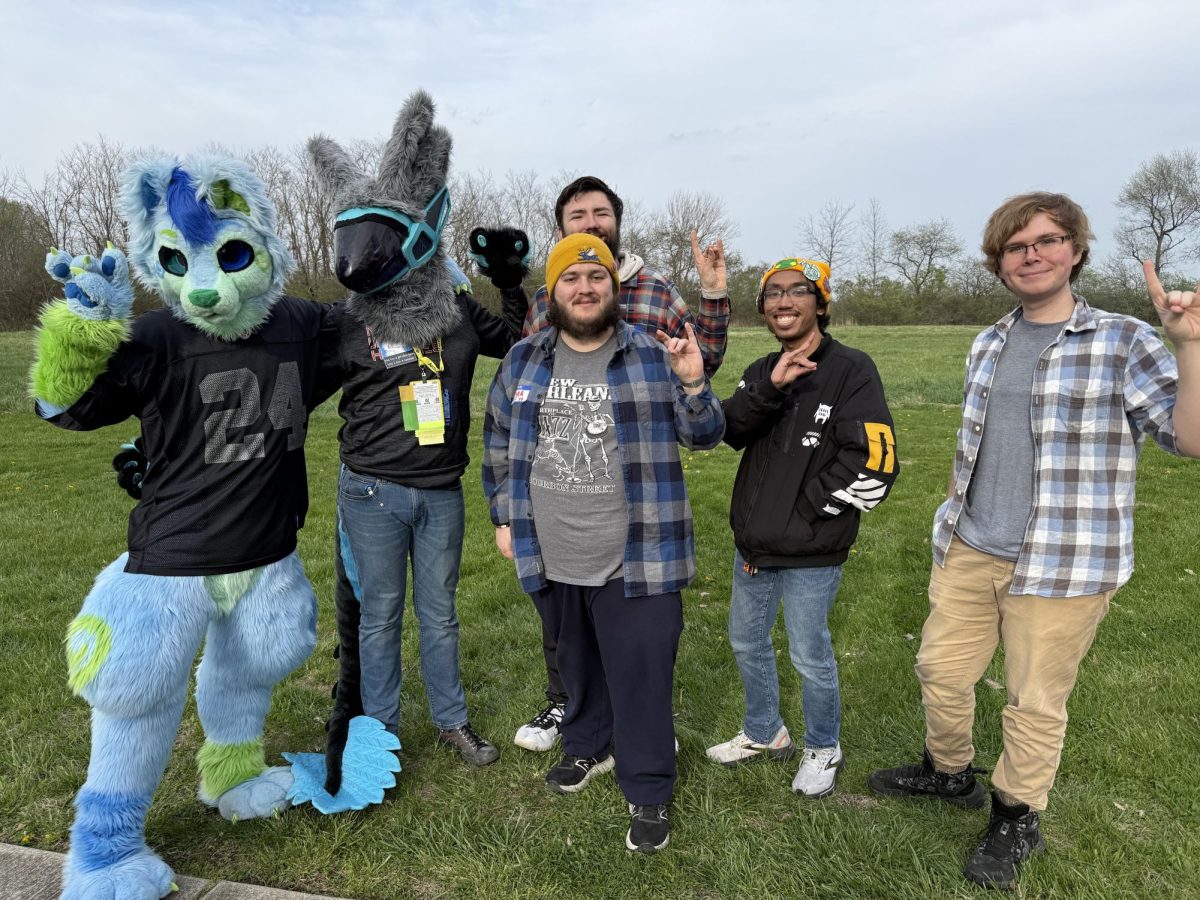Members of NIU’s Furry Club hold up the signature “husky” hand symbol while posing for a group photo. The club co-hosted the annual “Tri-Tails” inter-collegiate gathering for the first time since becoming an official club, celebrating aspects of the furry fandom with other Illinois universities. (Ryan Day | Northern Star)