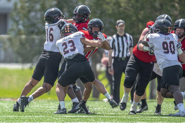 NIU redshirt junior linebacker Marc Pretto (23) initiates a tackle against redshirt freshman running back Romelo Ware (11) during 11-on-11 drills in NIU’s Spring Showcase on April 26 in DeKalb. Pretto is projected to have a larger role on NIU’s defense in 2025 as the starting weakside linebacker. (Totus Tuus Keely | Northern Star)
