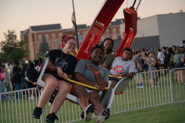 Addison Kimbler (left), a first-year art and design major, and Julia Smith, a junior early childhood education major, ride the Ballistic Swing carnival ride on Thursday at the Campus Activities Board Block Party. Long lines formed for the Ballistic Swing, zipline and lemonade stands. (Totus Tuus Keely | Northern Star)