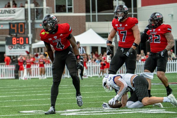 NIU redshirt senior safety Muhammed Jammeh (4) celebrates after tackling College of the Holy Cross senior wide receiver Max Mosey (13) for no gain during the first quarter of NIU’s season opener on Saturday at Huskie Stadium in DeKalb. Jammeh recorded NIU’s only takeaway of the game with an interception off a tipped pass in the first quarter. (Totus Tuus Keely | Northern Star)