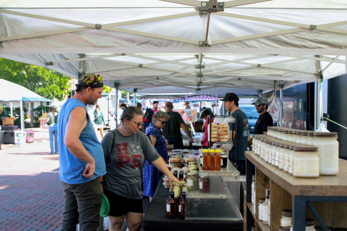 DeKalb Farmer’s Market attendees browse through a variety of products such as honey, breads and donuts. The DeKalb Farmer’s Market was held at 210 E. Locust St. between 10 a.m. and 2 p.m. (Ethan Rodriguez | Northern Star)