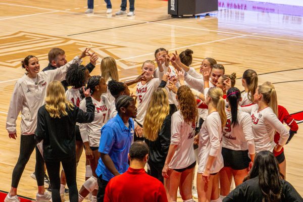 The NIU Volleyball team ends their pregame huddle with the Huskie hand sign on Aug. 22 before their exhibition match against DePaul University. The Huskies start the regular season on Friday with matches against Lamar University and Stetson University in the Stetson Hatters Invitational. (Totus Tuus Keely | Northern Star)