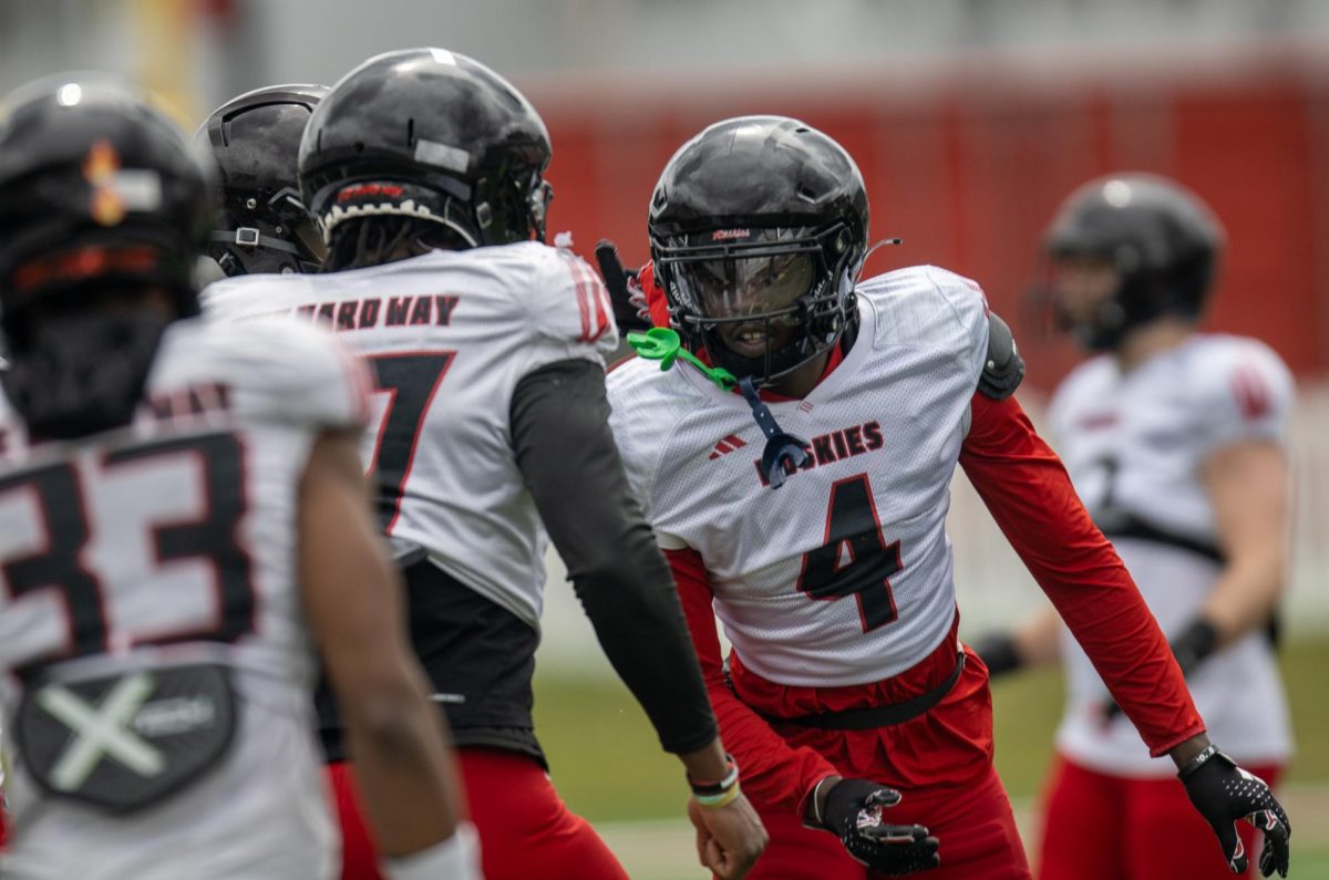 NIU redshirt senior safety Muhammed Jammeh (4) and senior defensive end Roy Williams celebrate during practice on April 5 at Huskie Stadium in DeKalb. Jammeh and Williams are listed as starters on NIU's defense heading to Saturday's season opener against Holy Cross. (Tim Dodge | Northern Star)