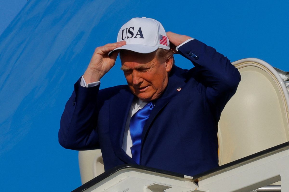 U.S. President Donald Trump adjusts a hat that says USA on it on June 24 as he disembarks Air Force One. Opinion Columnist Santiago Montañez Bertoletti argues that Trump's tactics to bring jobs in the U.S has failed American workers. (Reuters | Brian Snyder)