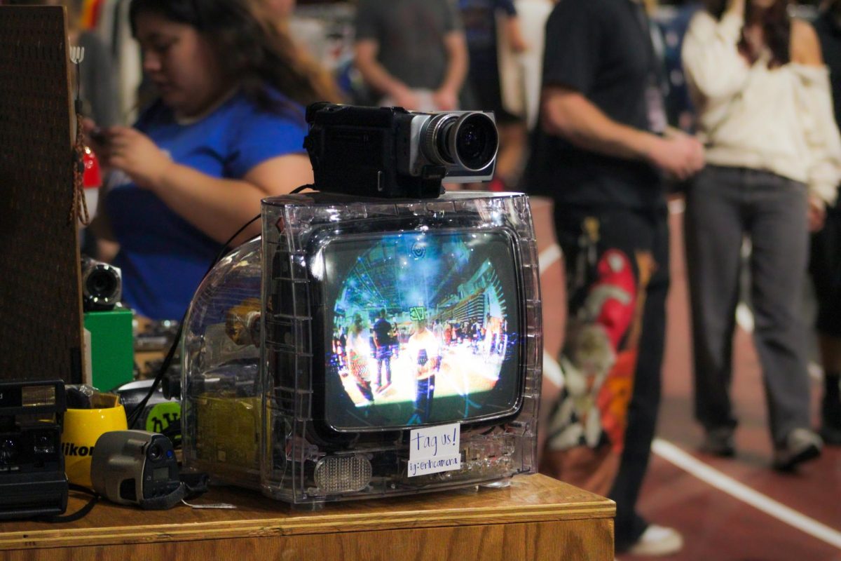 A 2000s Sony camcorder plays live footage of Illinois Vintage Fest attendees on a CRT TV at the NH Camera booth. NH Camera is a Chicago based small business founded in 2015 that specializes in selling older cameras. (Ethan Rodriguez | Northern Star)