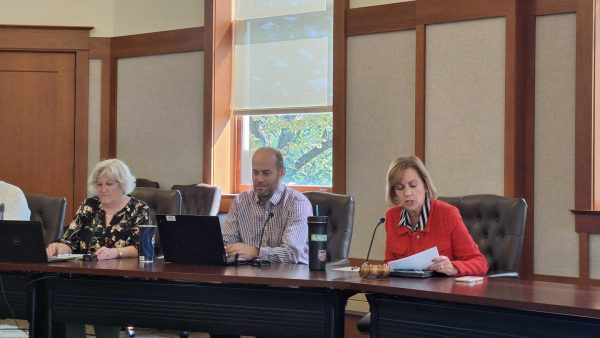 (From left) Administrative Assistant Pat Erickson, University Council President Benjamin Creed and Executive Vice President and Provost Laurie Elish-Piper at the council table during a University Council meeting. The University Council discussed increased enrollment and updates to the new budget for fiscal year 2026 in their Wednesday meeting. (Joseph Ndu |  Northern Star)