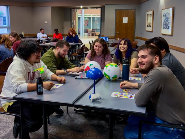 The group of Lotería Game Night attendees focus on caller Elbia Menéndez as they were about to win on Wednesday at Lotería Game Night in the Peters Campus Life Building. Lotería Game Night was moved from the Holmes Student Center to the Peters Campus Life Building. (Sofia Howell | Northern Star) 