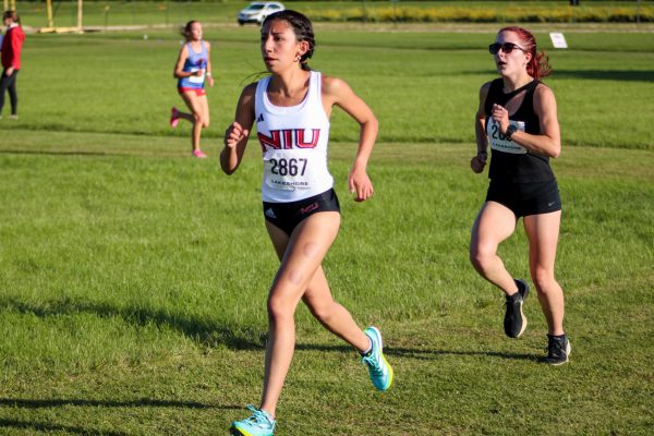 NIU freshman Amelie Ojeda (left) and NIU graduate runner Sarah Maggio (right) dash toward the first hill of the course near the 2 kilometer mark. Maggio placed 7th with a time of 18:42.20 at the 5K Huskie Invitational on Friday. (Ethan Rodriguez | Northern Star)