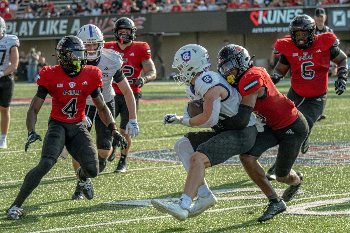 NIU redshirt junior cornerback Jacob Finley (3) wraps up College of the Holy Cross senior wide receiver Max Mosey (13) for a tackle in the fourth quarter of the Huskies’ season opener on Aug. 30 at Huskie Stadium in DeKalb. NIU will host San Diego State University on Saturday in the seventh all-time meeting between the schools. (Totus Tuus Keely | Northern Star)