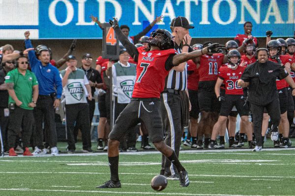 Senior cornerback Donte Harrison (7) reaches his arms to the sky to celebrate an incomplete pass in the final two minutes of the fourth quarter on Saturday against the College of the Holy Cross. NIU led the rushing game with 178 yards compared to Holy Cross’s 62, but fell behind in passing with 109 yards to 155. (Totus Tuus Keely | Northern Star)