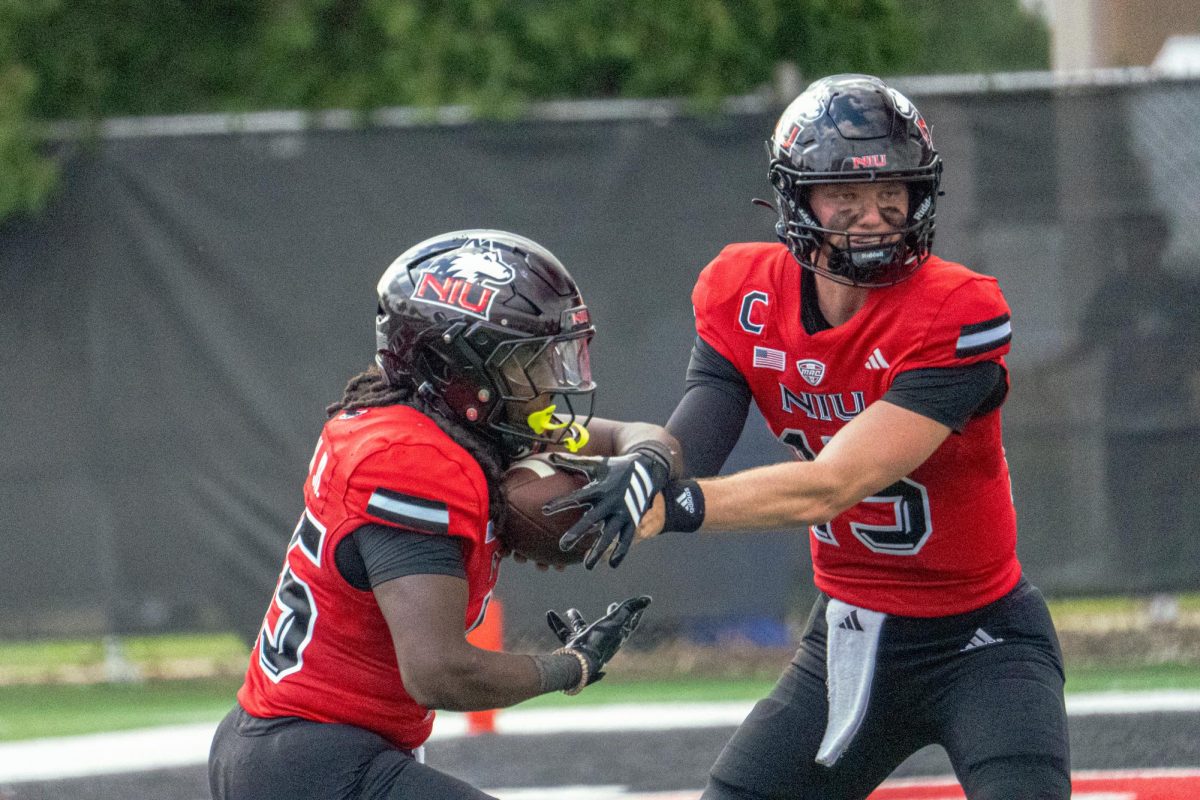 NIU redshirt sophomore quarterback Josh Holst (15) hands off to sophomore running back Telly Johnson Jr. (45) during the first half of the Huskies' home opener against College of the Holy Cross on Aug. 30 at Huskie Stadium in DeKalb. According to The Daily Aztec Sports Editor Roman Aguilar, NIU's run-heavy offense will be challenged by San Diego State's defense during their matchup on Saturday. (Totus Tuus Keely | Northern Star) 