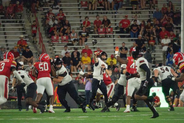 NIU football redshirt sophomore quarterback Josh Holst (15) passes the ball to sophomore running back Telly Johnson Jr. (45) during the Huskies’ 20-9 loss against the University of Maryland. The Northern Star Sports staff shares their predictions for the outcomes of five college football games scheduled to take place this weekend. (Totus Tuus Keely | Northern Star)