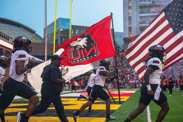 NIU football head coach Thomas Hammock and players run onto the field before the Huskies’ non-conference game against the University of Maryland on Sept. 5 at SECU Stadium in College Park, Maryland. NIU will play another Power Four opponent Saturday when they face Mississippi State University. (Northern Star file photo)