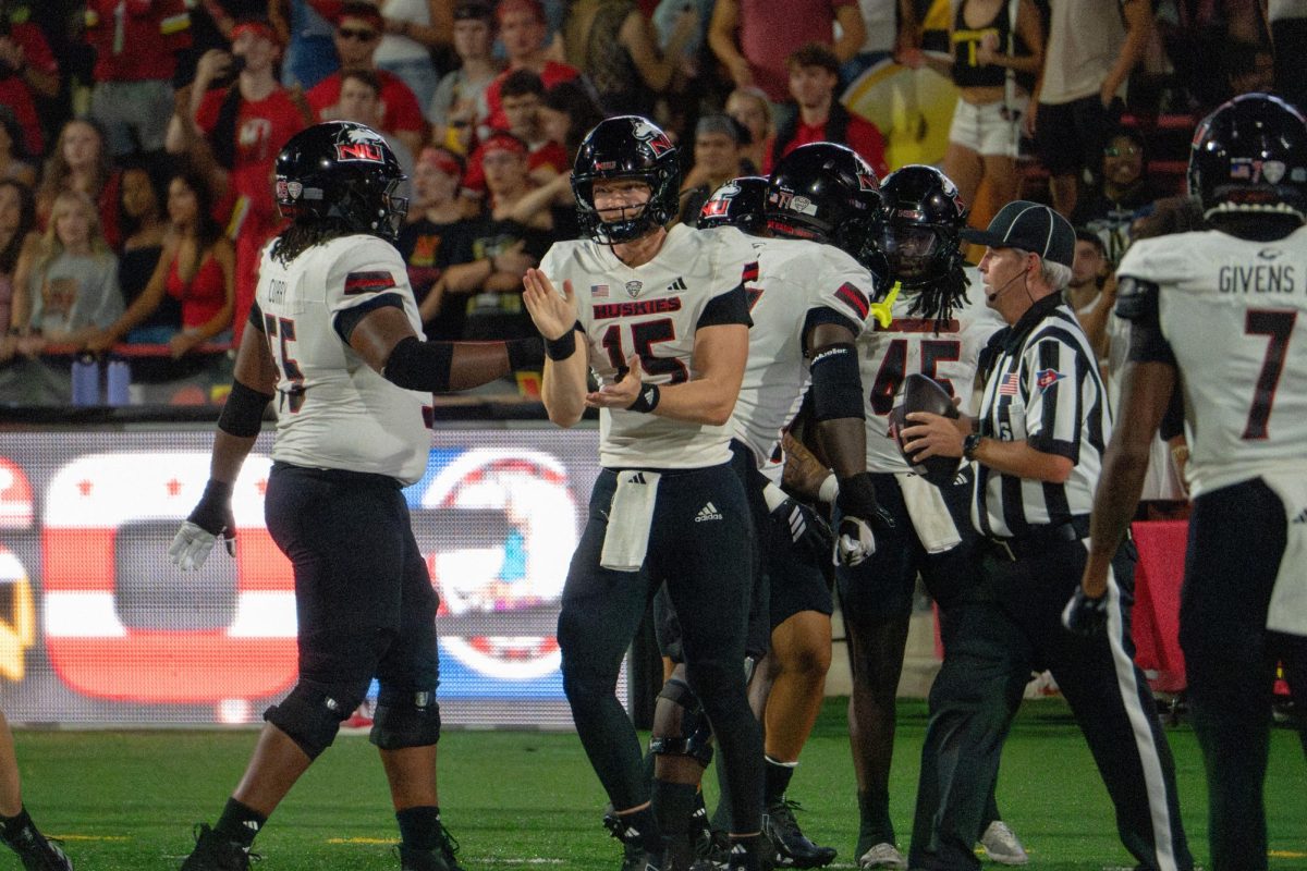 NIU football redshirt sophomore quarterback Josh Holst (15) claps after sophomore running back Telly Johnson Jr. (45) scored a 74 yard touchdown in the third quarter on Sept. 5 at University of Maryland in College Park, Maryland. The Northern Star Sports staff shares their predictions for the outcomes of five college football games scheduled to take place this weekend. (Totus Tuus Keely | Northern Star)