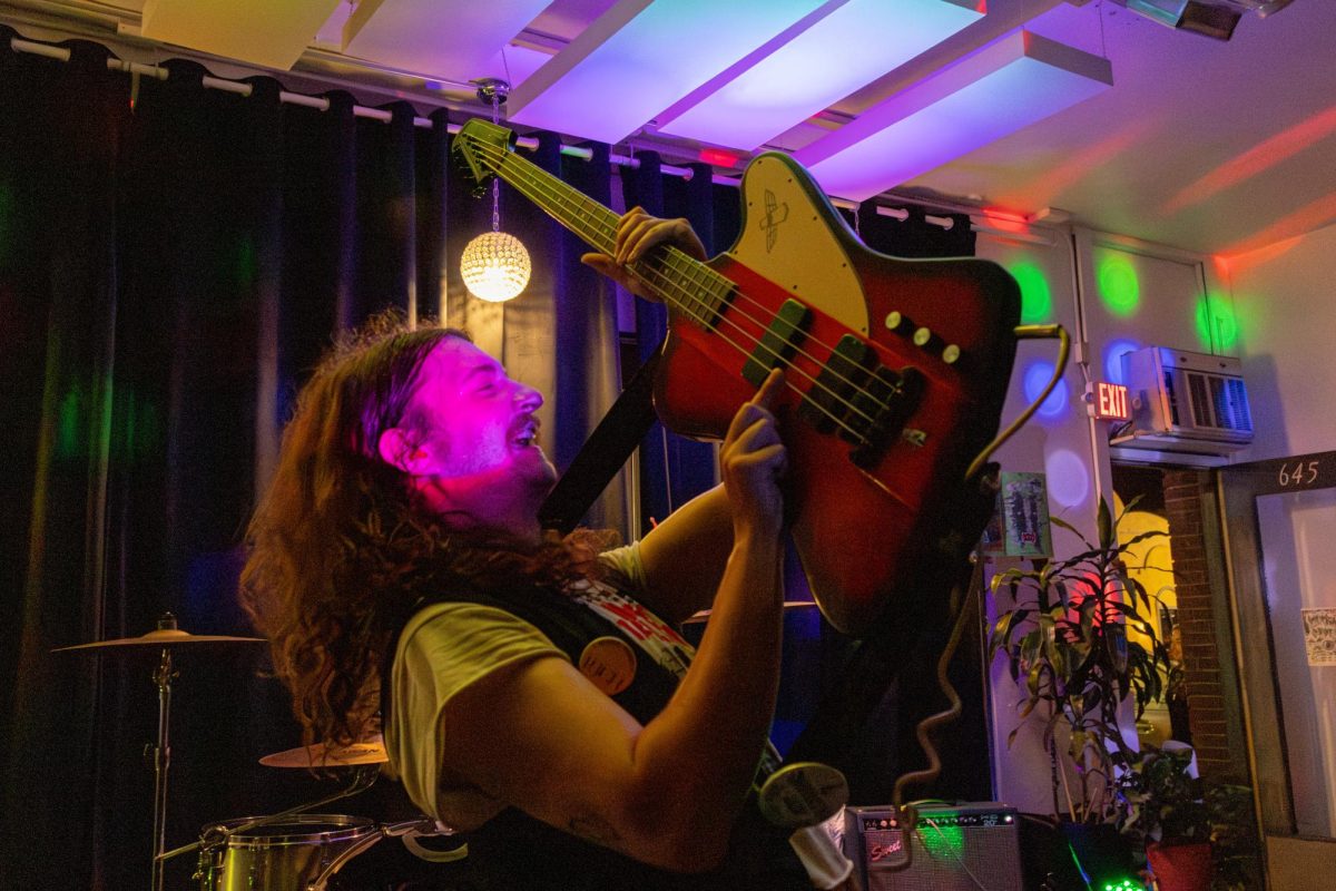Bassist JM Graveside hoists his bass above his head while playing at the Fargo Venue Saturday. Graveside jumped off stage toward the end of the show to get closer to the audience. (Brynn Krug | Northern Star)