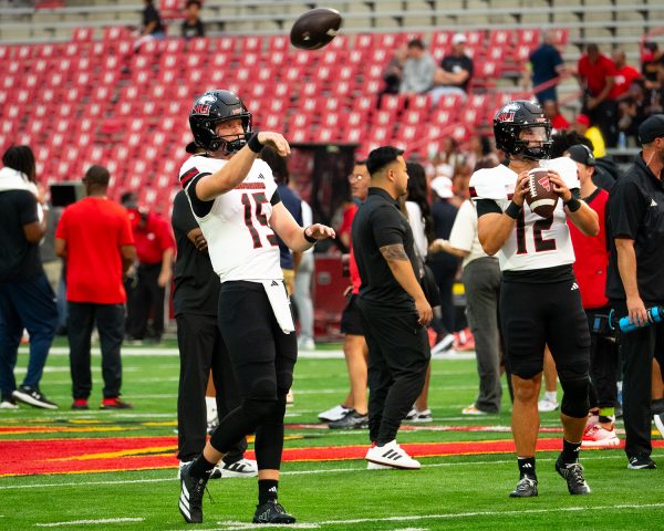 NIU football junior quarterback Josh Holst (15) (left) completes his follow-through while redshirt junior quarterback Jackson Proctor (12) prepares to throw a pass during pregame warmups Friday at SECU Stadium in College Park, Maryland. Travelling to face the University of Maryland Terrapins for the first time since 2004, NIU went into halftime facing a seven-point deficit. (Totus Tuus Keely | Northern Star)
